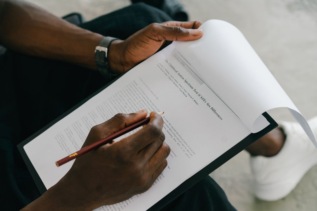 Close-up of a person writing on a psychological assessment form with a pencil.